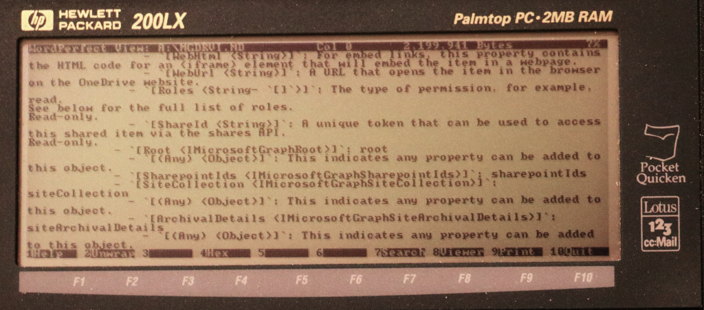 Photo of a HP 200LX Palmtop PC with 2MB of RAM. The screen shows WordPerfect view of MGDRVI.MD, 2,199,941 bytes, at 7%. The screen is full of text, first two lines containing - `[WebHtml <String>]`: For embed links, this property contains the HTML code for an <iframe> element that will embed the item in a webpage. [...]